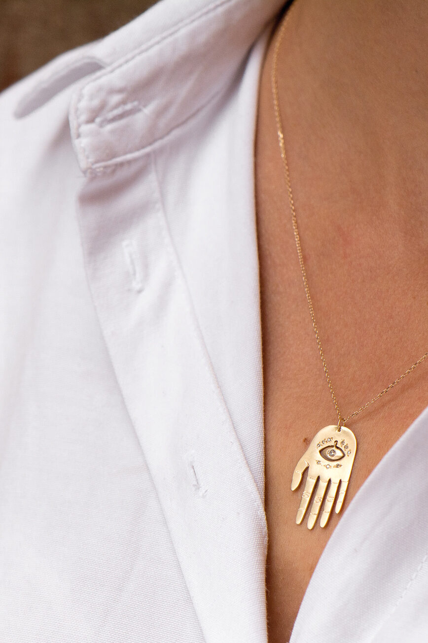 Yellow gold necklace large sculpted hand pendant diamond eye motif chain Celine Daoust