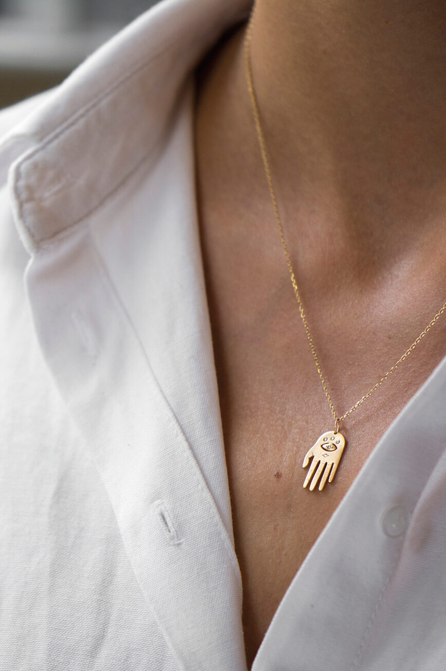 Yellow gold necklace small sculpted hand pendant diamond eye motif chain Celine Daoust