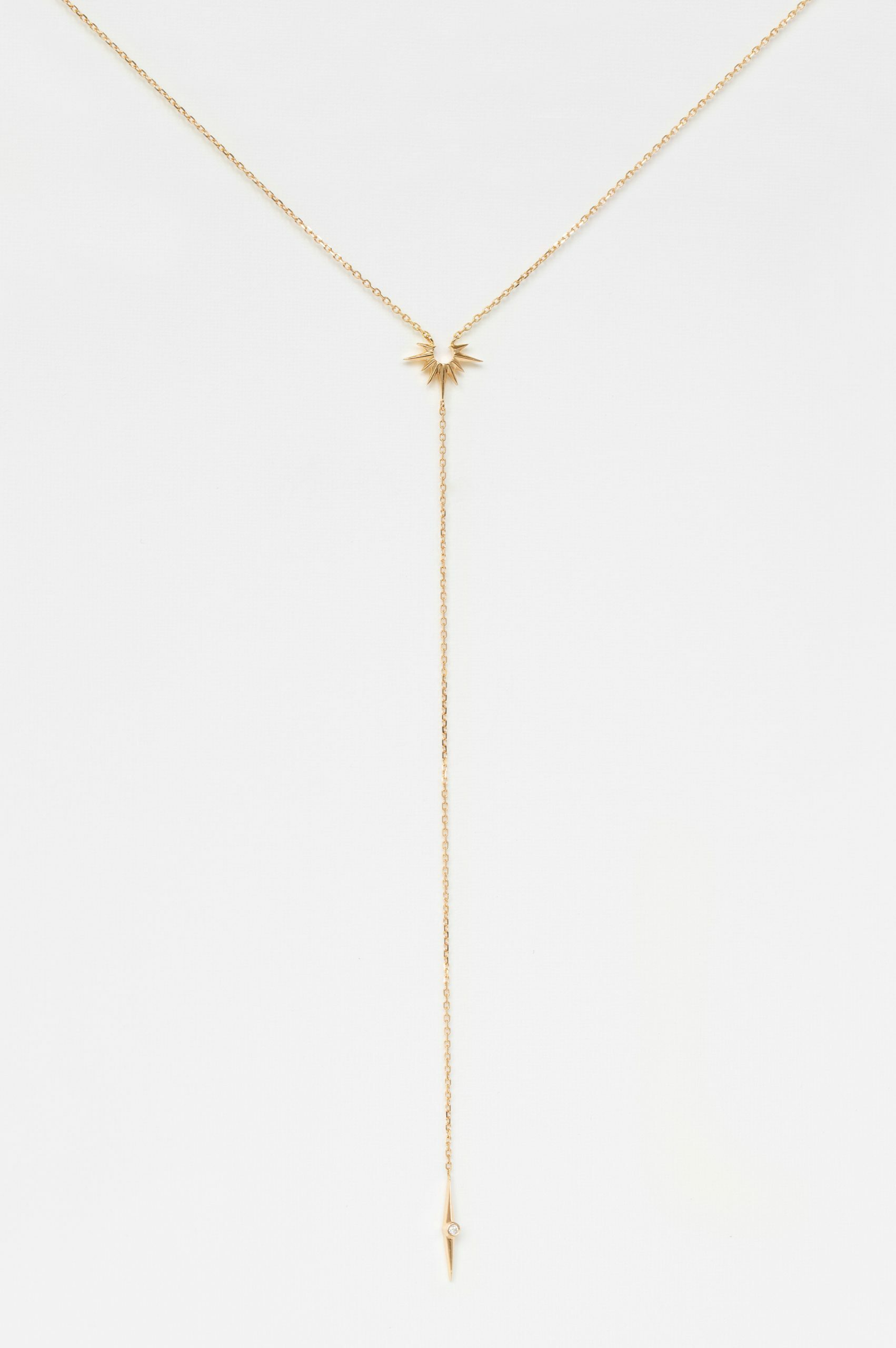 yellow gold lariat necklace with a fine chain ending in a small eight-pointed star pendant set with a round brilliant diamond