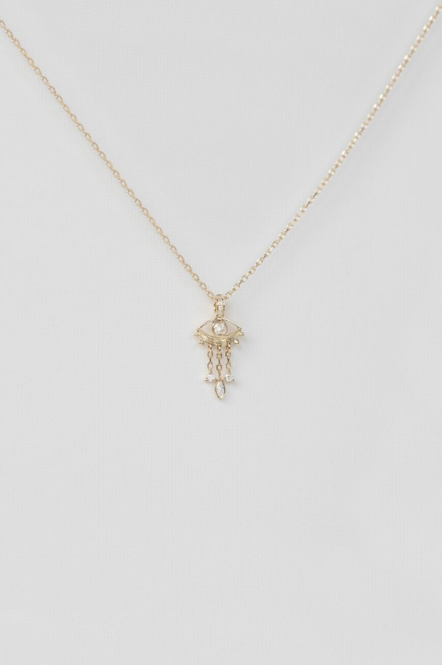 yellow gold necklace with a delicate jellyfish-shaped pendant featuring a central diamond eye and three fine dangling chain drops
