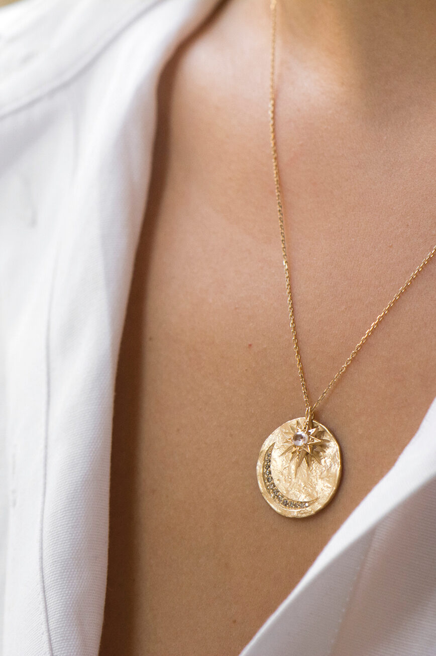 Yellow gold necklace round textured medal pendant diamond sapphire star moon eye motif Celine Daoust
