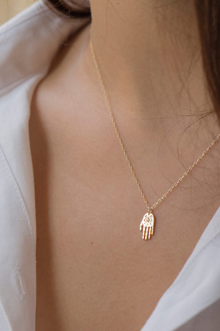 Yellow gold necklace small sculpted hand pendant diamond eye motif delicate chain Celine Daoust