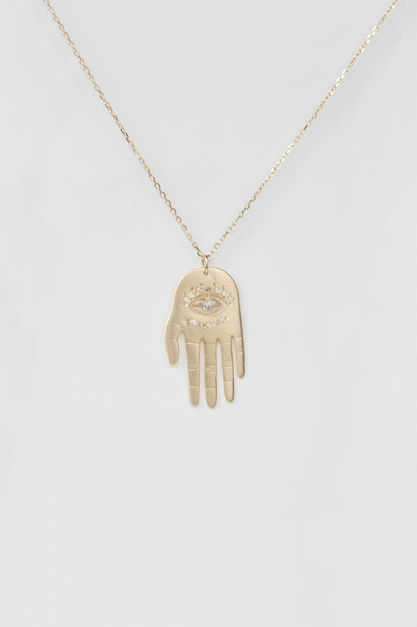 Yellow gold necklace large sculpted hand pendant diamond eye motif chain Celine Daoust