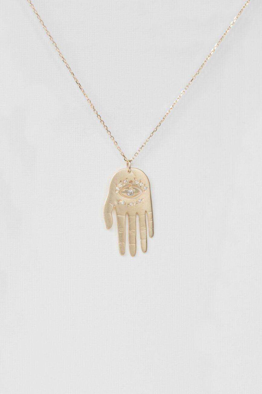 Yellow gold necklace large sculpted hand pendant diamond eye motif chain Celine Daoust