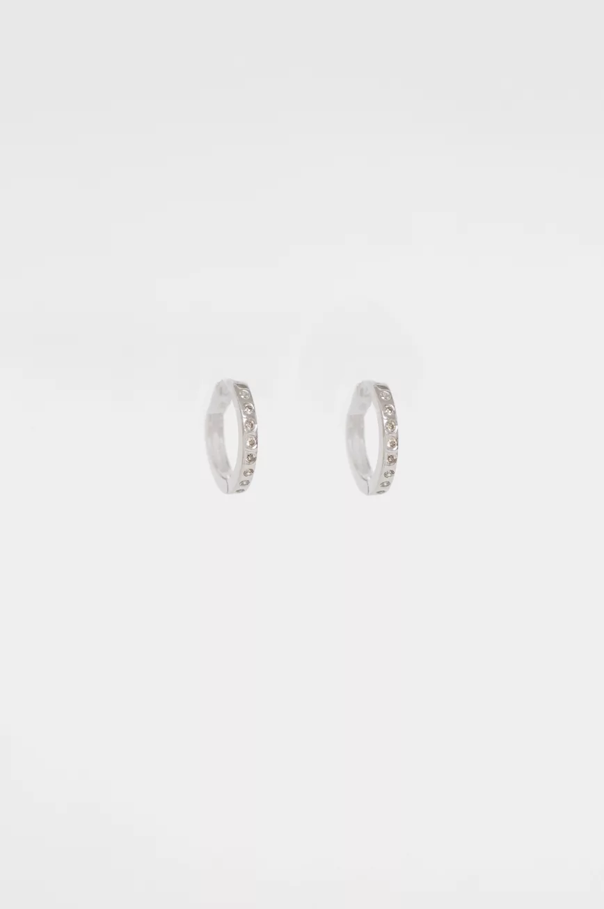 white gold small hoop earrings with a continuous pavé line of round brilliant diamonds along the front of the hoop