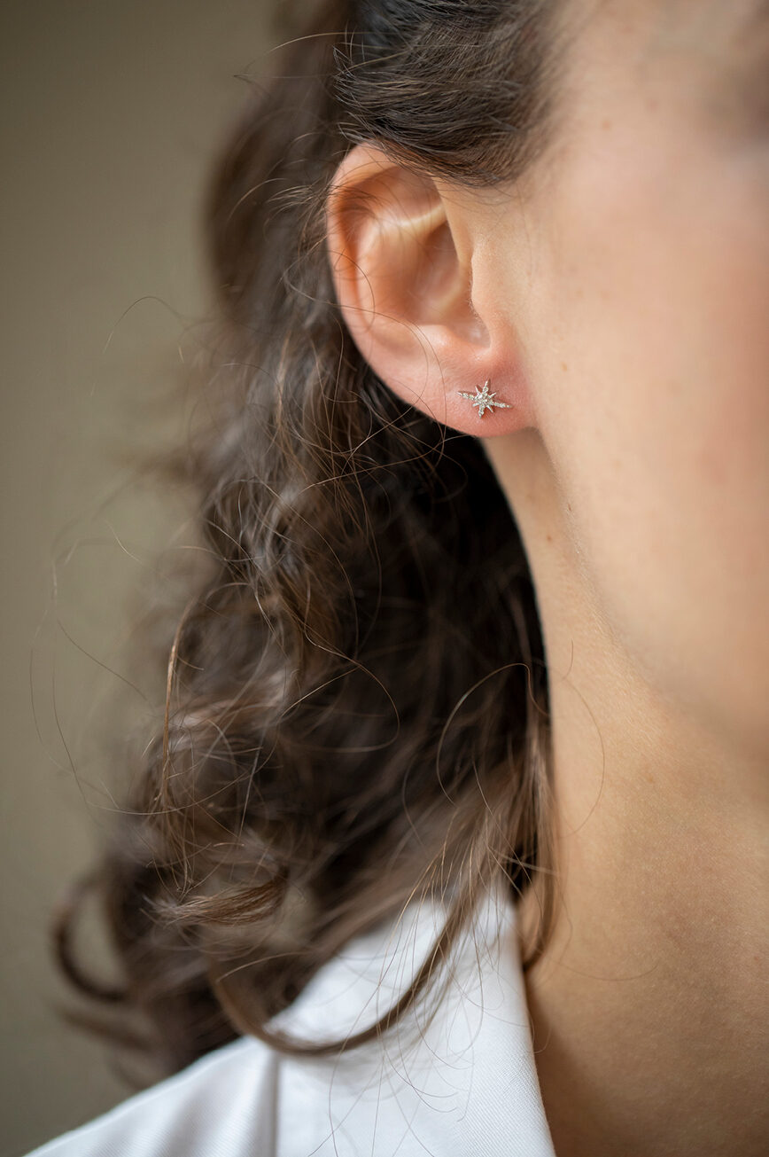 white gold stud earrings each featuring an eight-pointed north star pavé-set with round brilliant diamonds