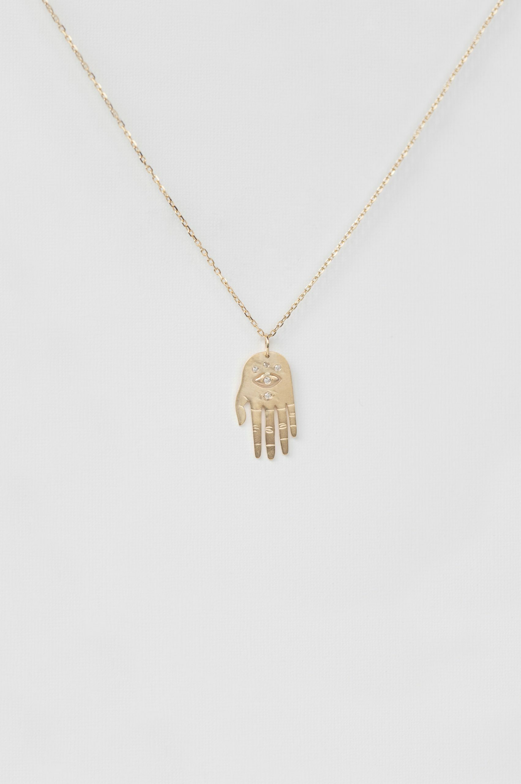 Yellow gold necklace small sculpted hand pendant diamond eye motif chain Celine Daoust