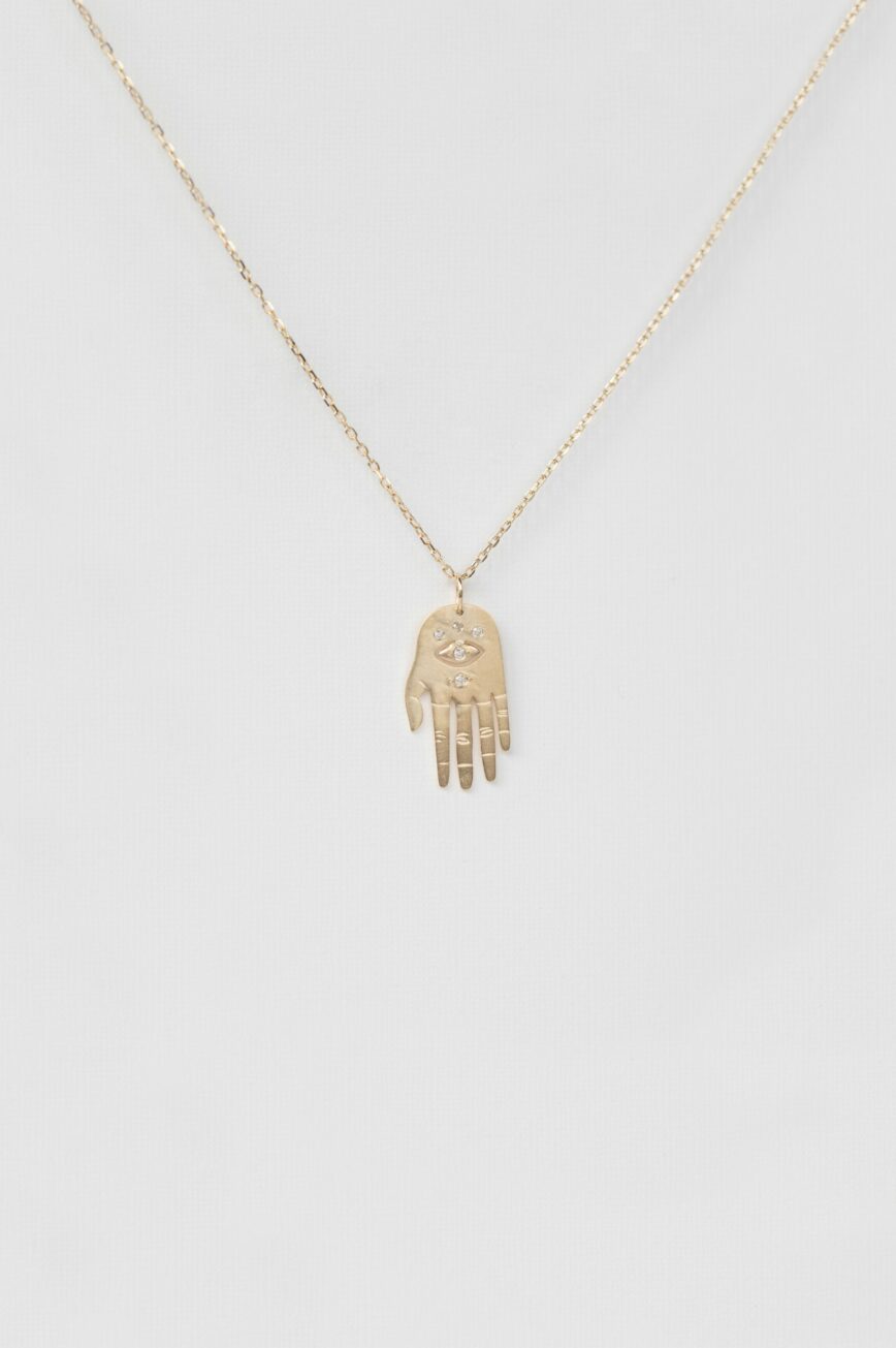 Yellow gold necklace small sculpted hand pendant diamond eye motif chain Celine Daoust