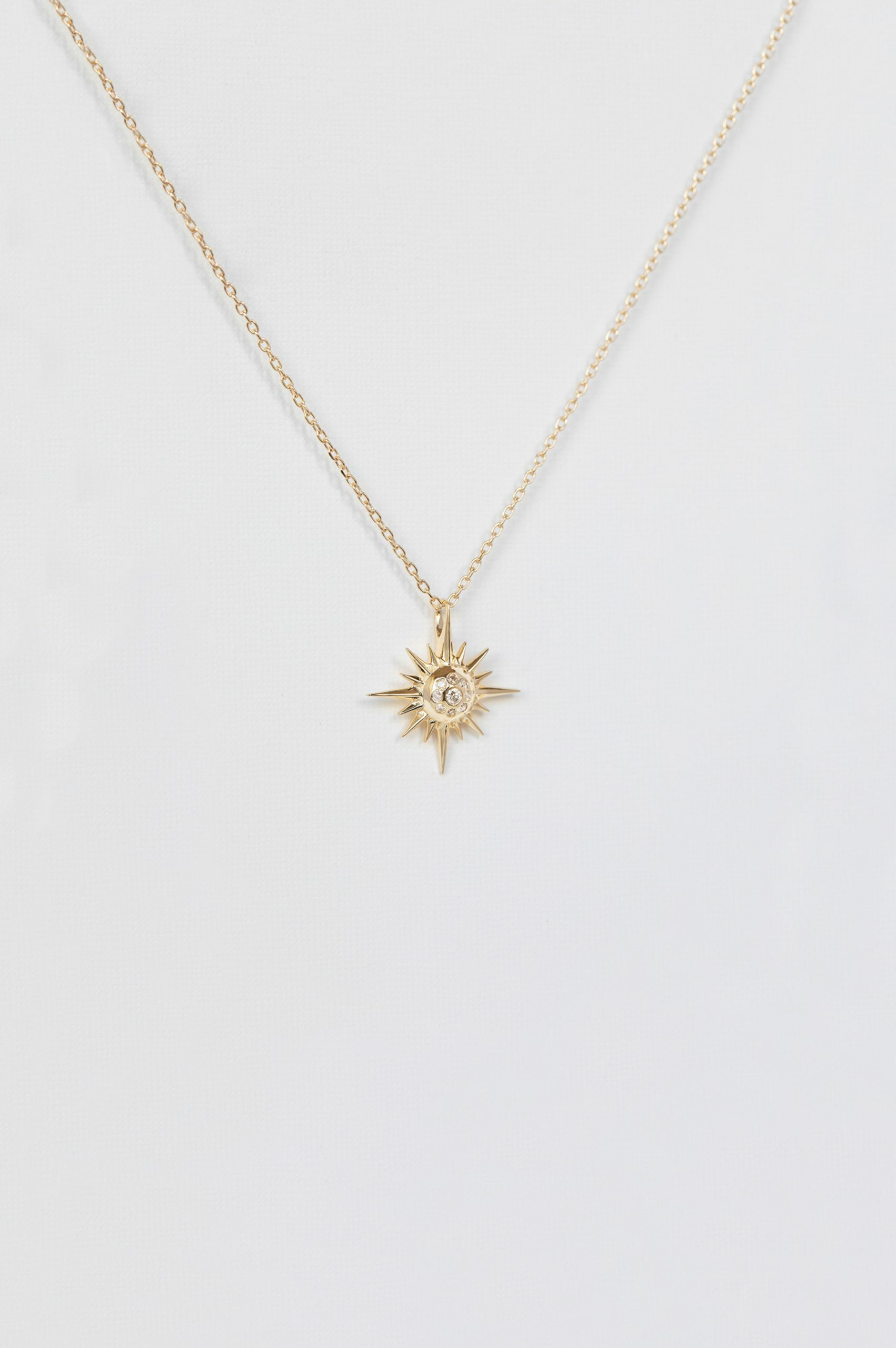 Yellow gold necklace sculpted sun ray pendant diamond center delicate chain Celine Daoust