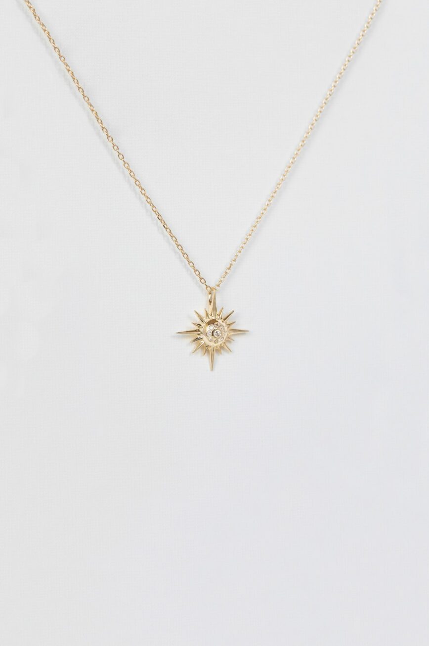 Yellow gold necklace sculpted sun ray pendant diamond center delicate chain Celine Daoust