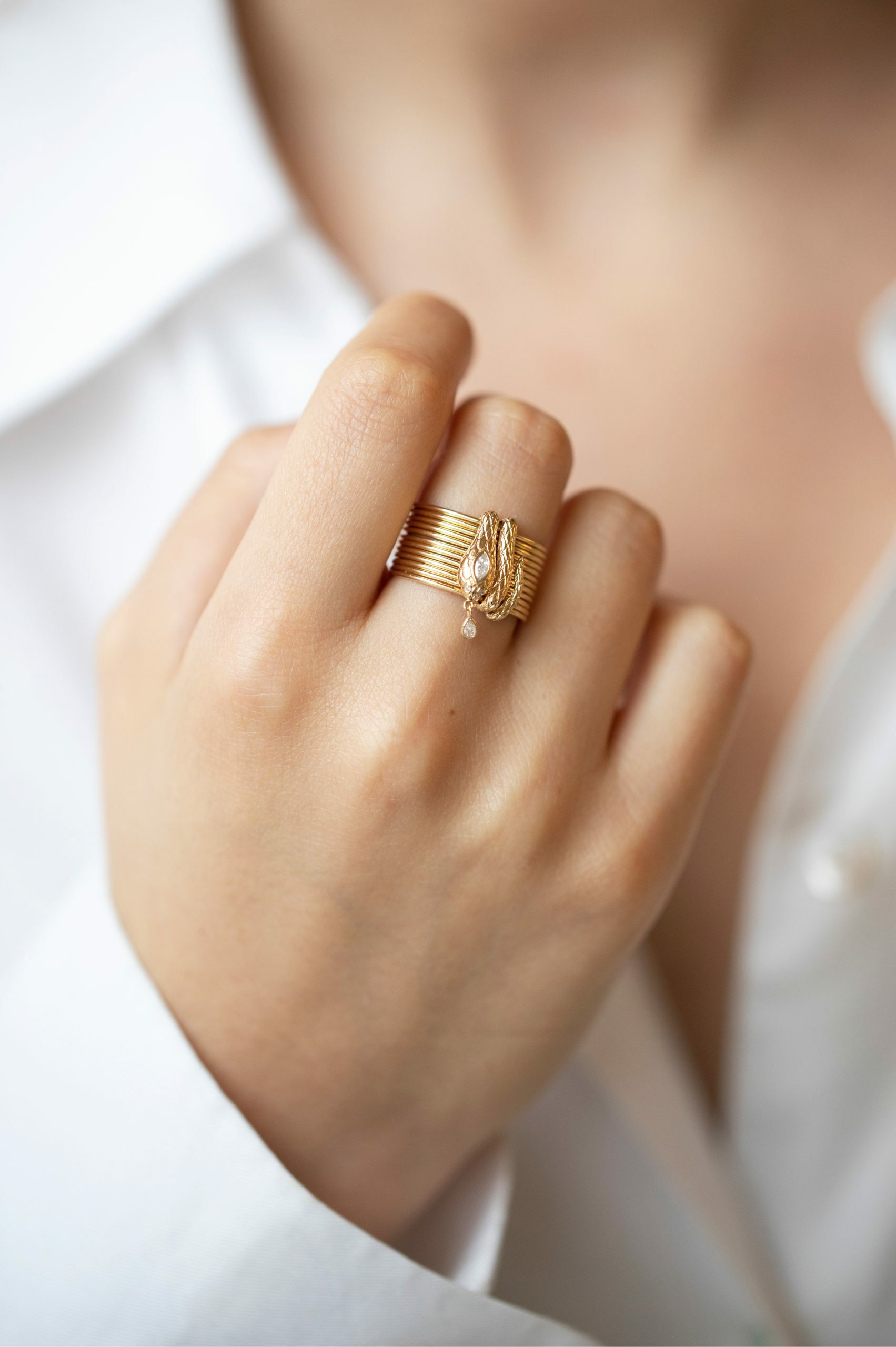 Yellow gold stacked multi-band ring sculpted cobra motif diamond drop charm Celine Daoust