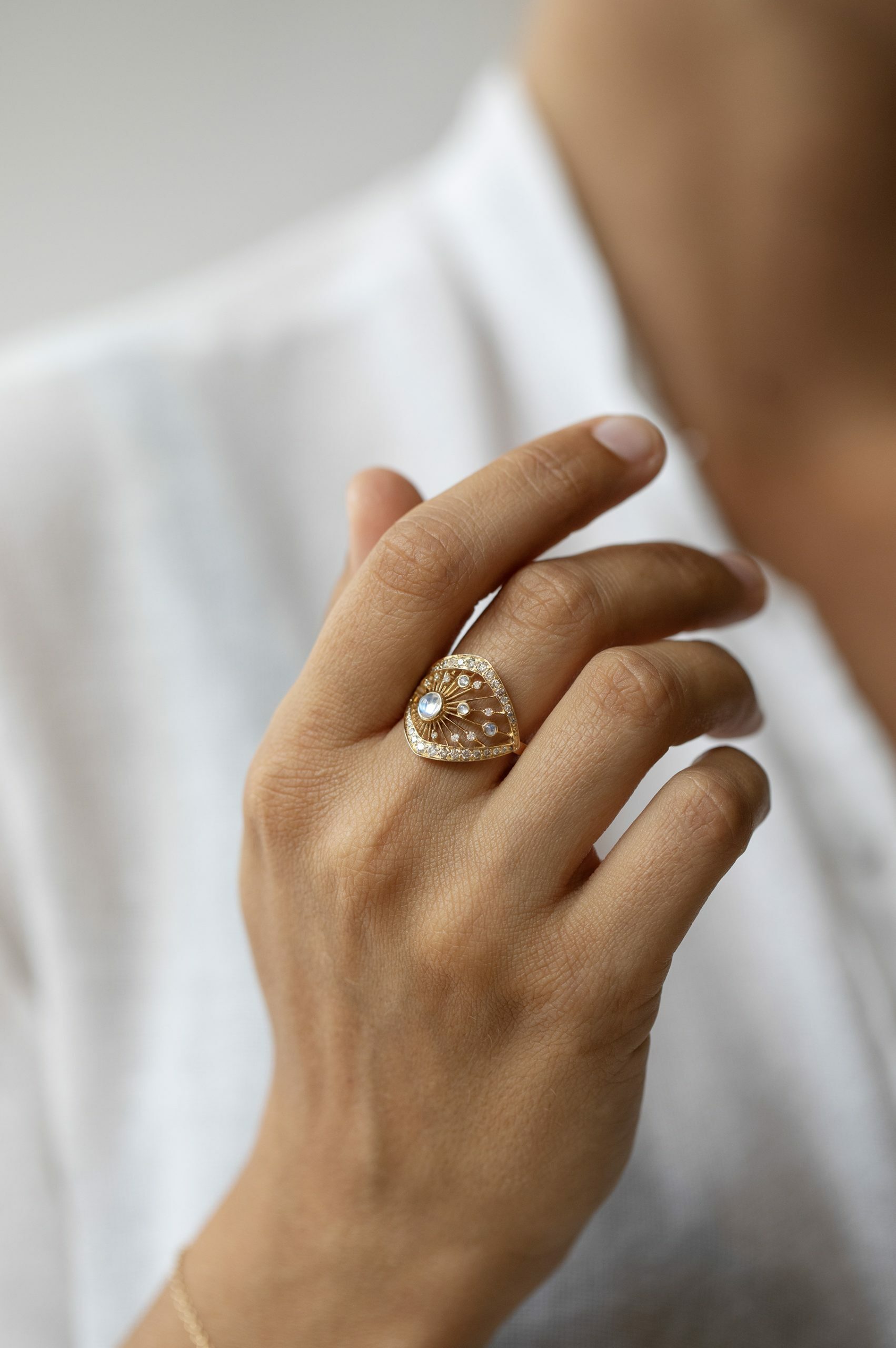 Yellow gold wide ring round moonstone open filigree frame pavé diamond border Celine Daoust