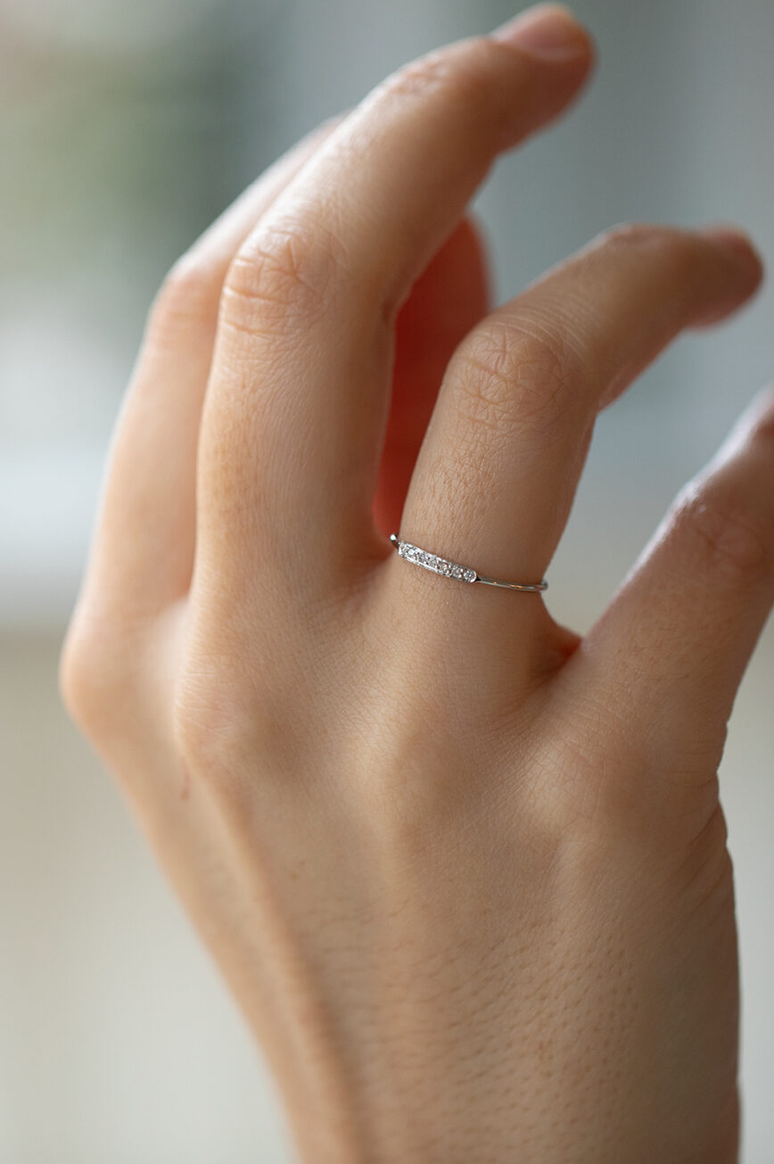 white gold slim band ring featuring a central rectangular pavé bar set with a row of tiny round brilliant diamonds