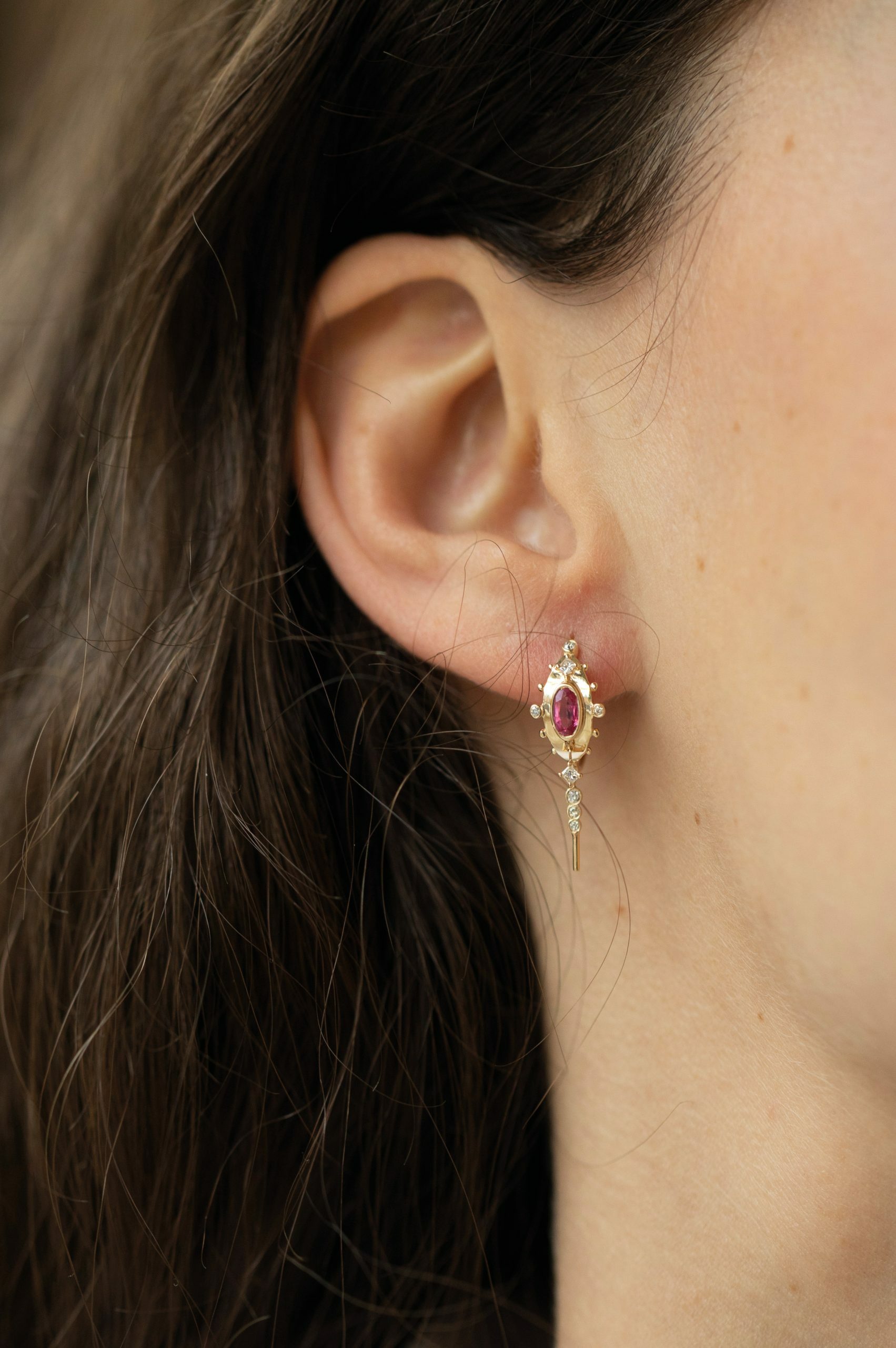 Yellow gold single drop earring vivid pink spinel oval eye diamond square accents worn on ear Celine Daoust
