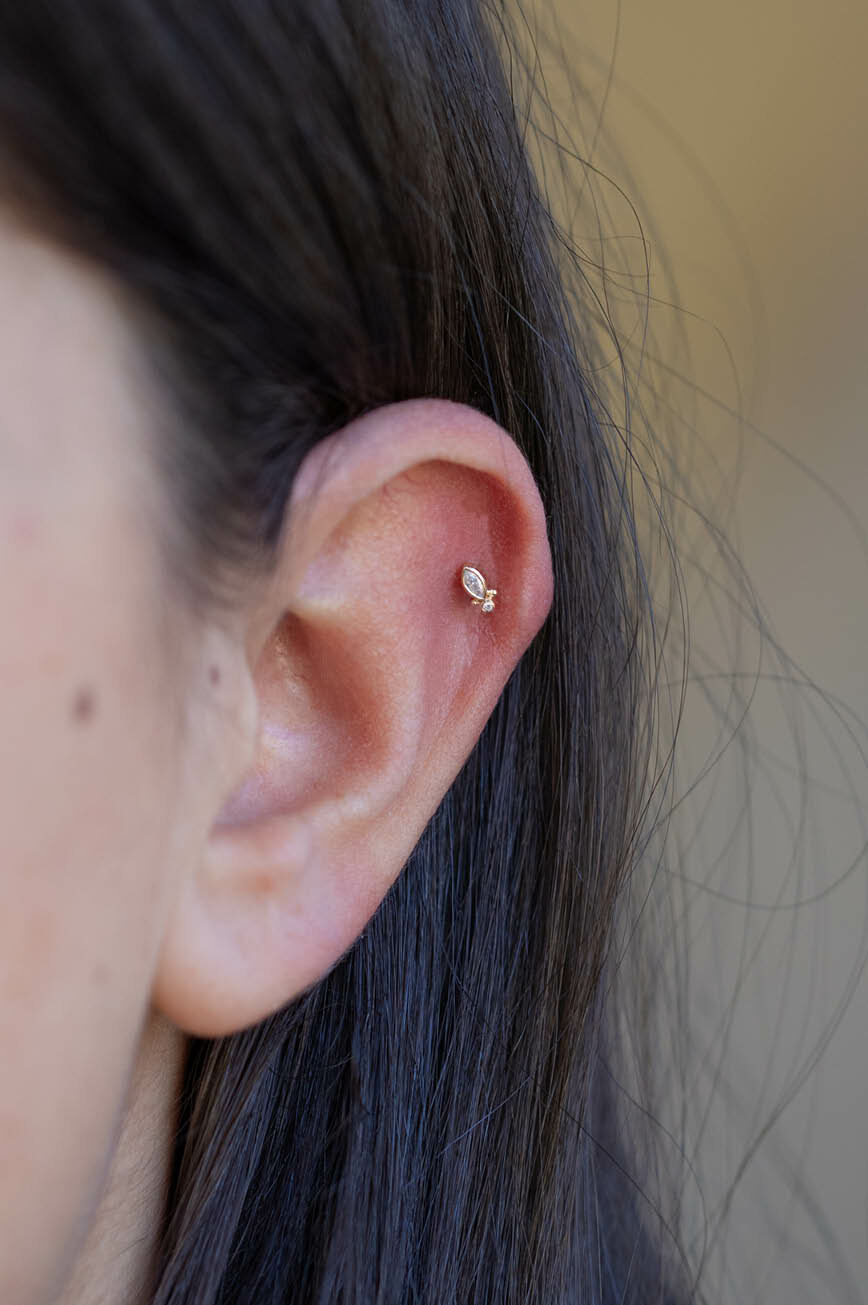 Yellow gold flat back piercing marquise diamond stud worn on ear Celine Daoust