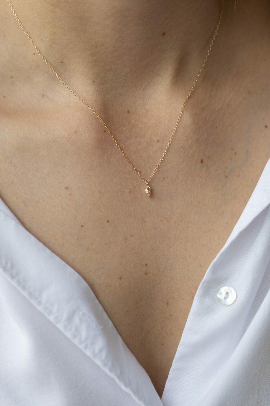 Yellow gold necklace small sculpted shell charm pendant delicate chain Celine Daoust