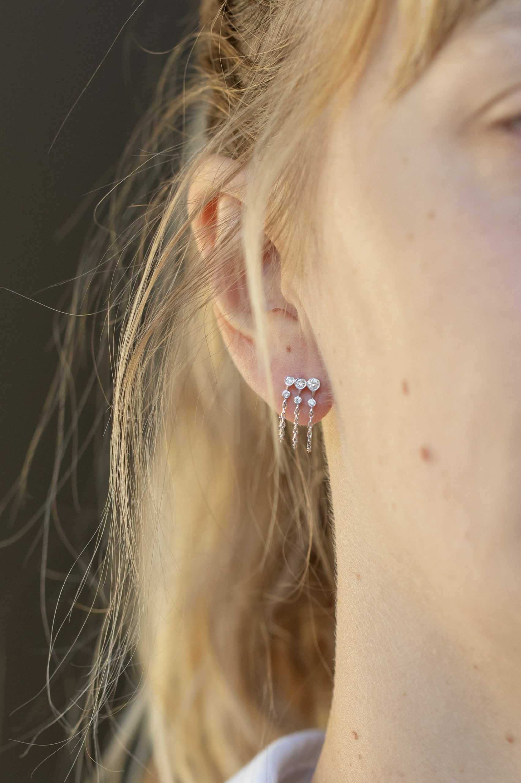 white gold chain earrings with three diamond constellation clusters set along a delicate chain, worn as an ear crawler