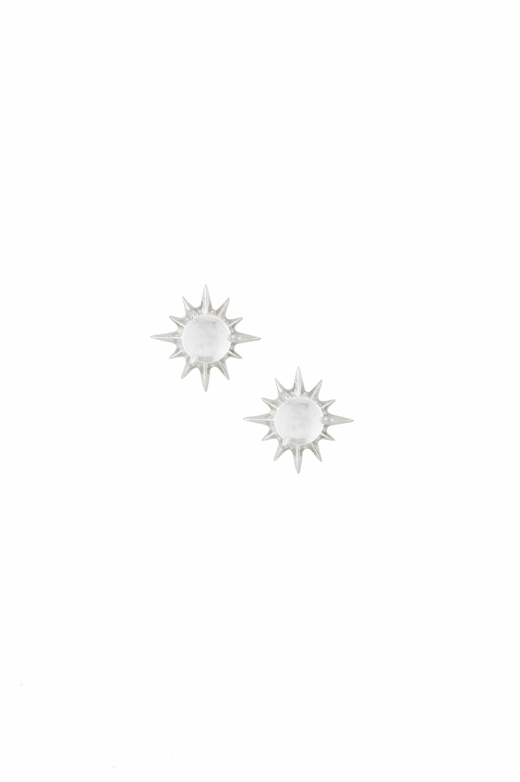 white gold stud earrings each featuring a round moonstone cabochon at center surrounded by radiating spike rays, evoking a celestial sun