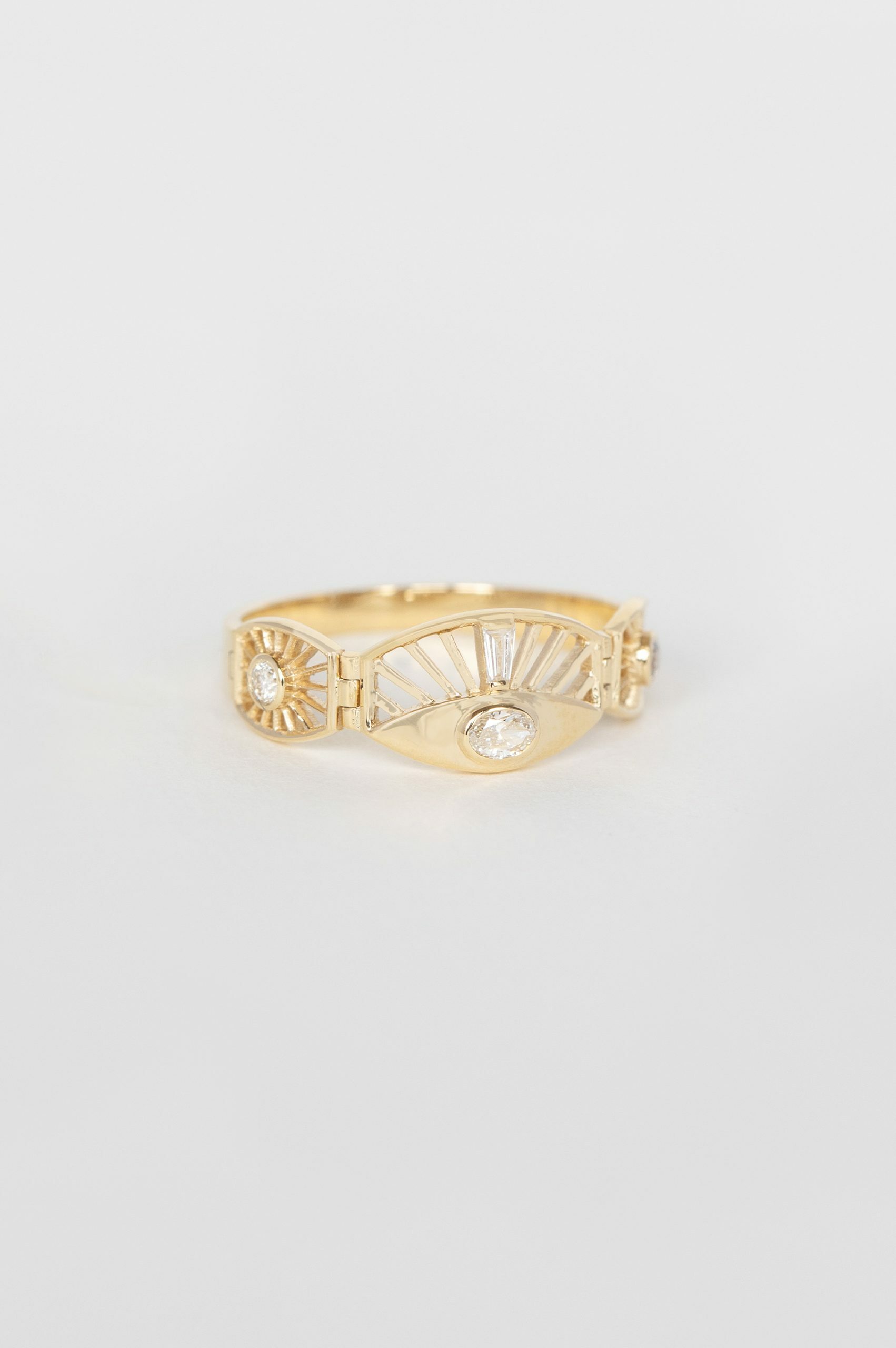 Yellow gold wide articulated ring oval diamond sun ray eye motif baguette accents Celine Daoust