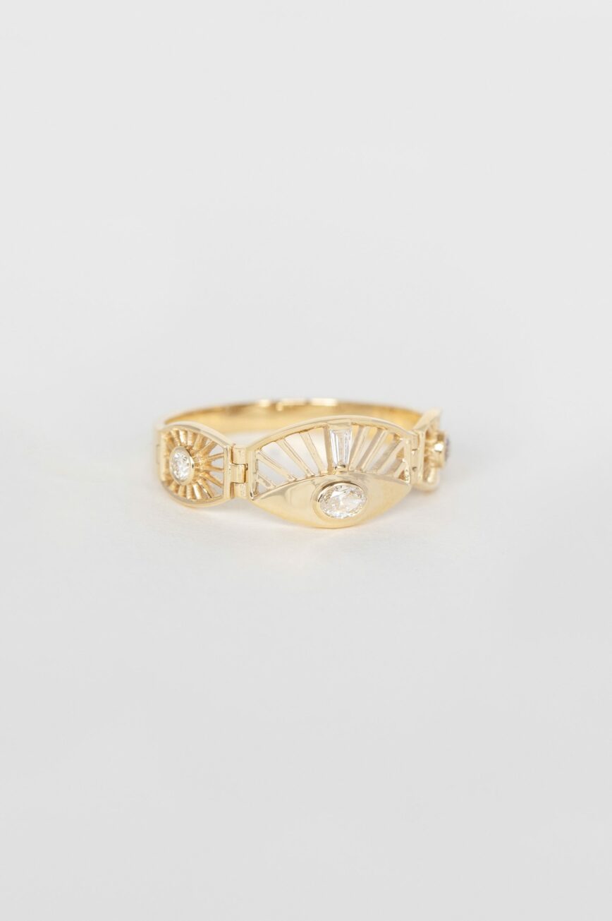 Yellow gold wide articulated ring oval diamond sun ray eye motif baguette accents Celine Daoust