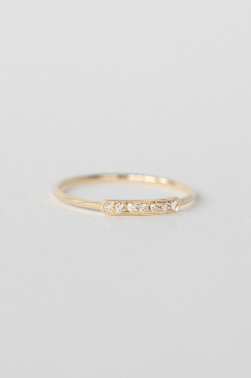 Yellow gold slim band ring multiple small bezel-set diamonds bar Celine Daoust