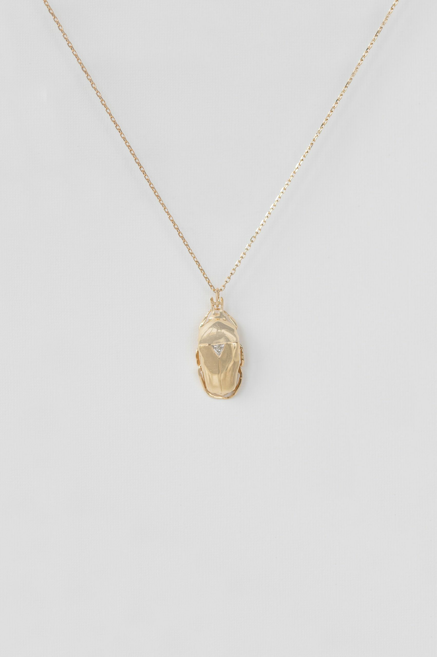 Yellow gold necklace sculpted scarab pendant trillion diamond accent chain Celine Daoust