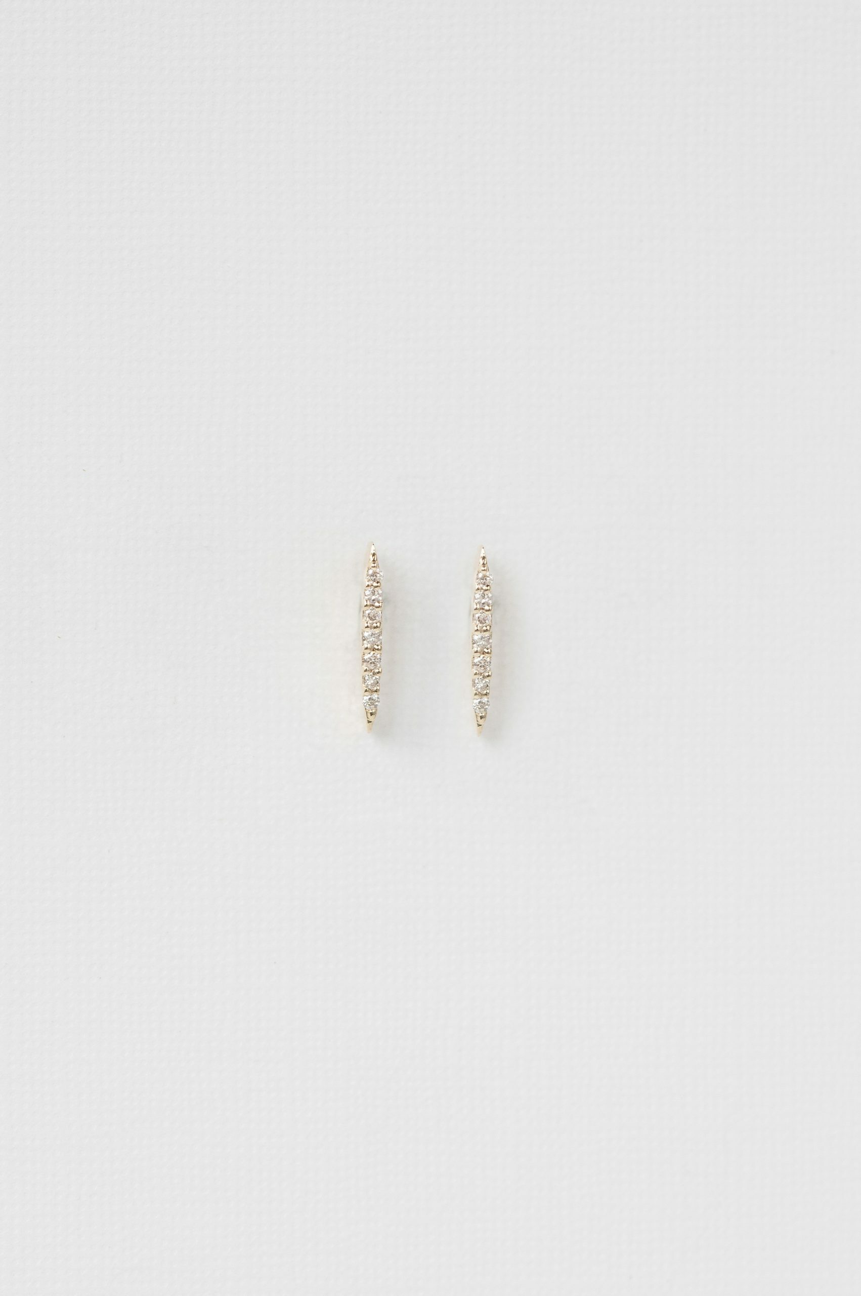 yellow gold linear bar stud earrings set with a vertical row of small pavé diamonds, slim and architectural
