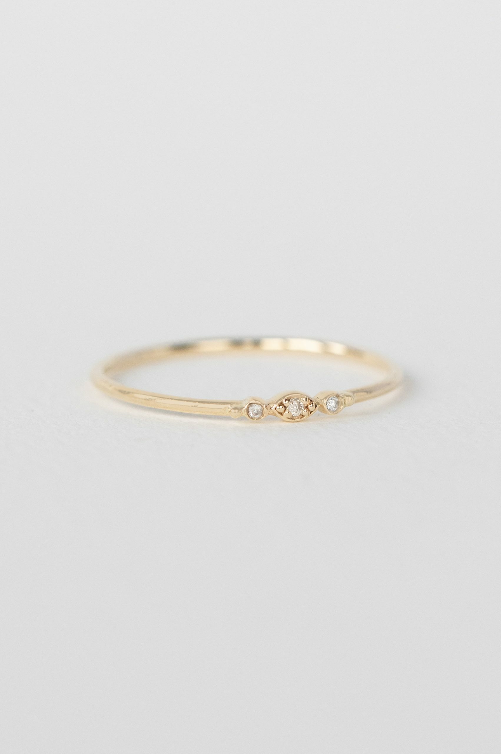 Gold ring three tiny diamonds eye motif slim band Celine Daoust