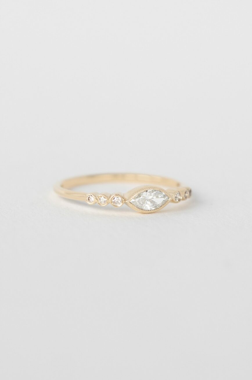 Yellow gold ring marquise diamond six bezel-set diamond accents slim band Celine Daoust