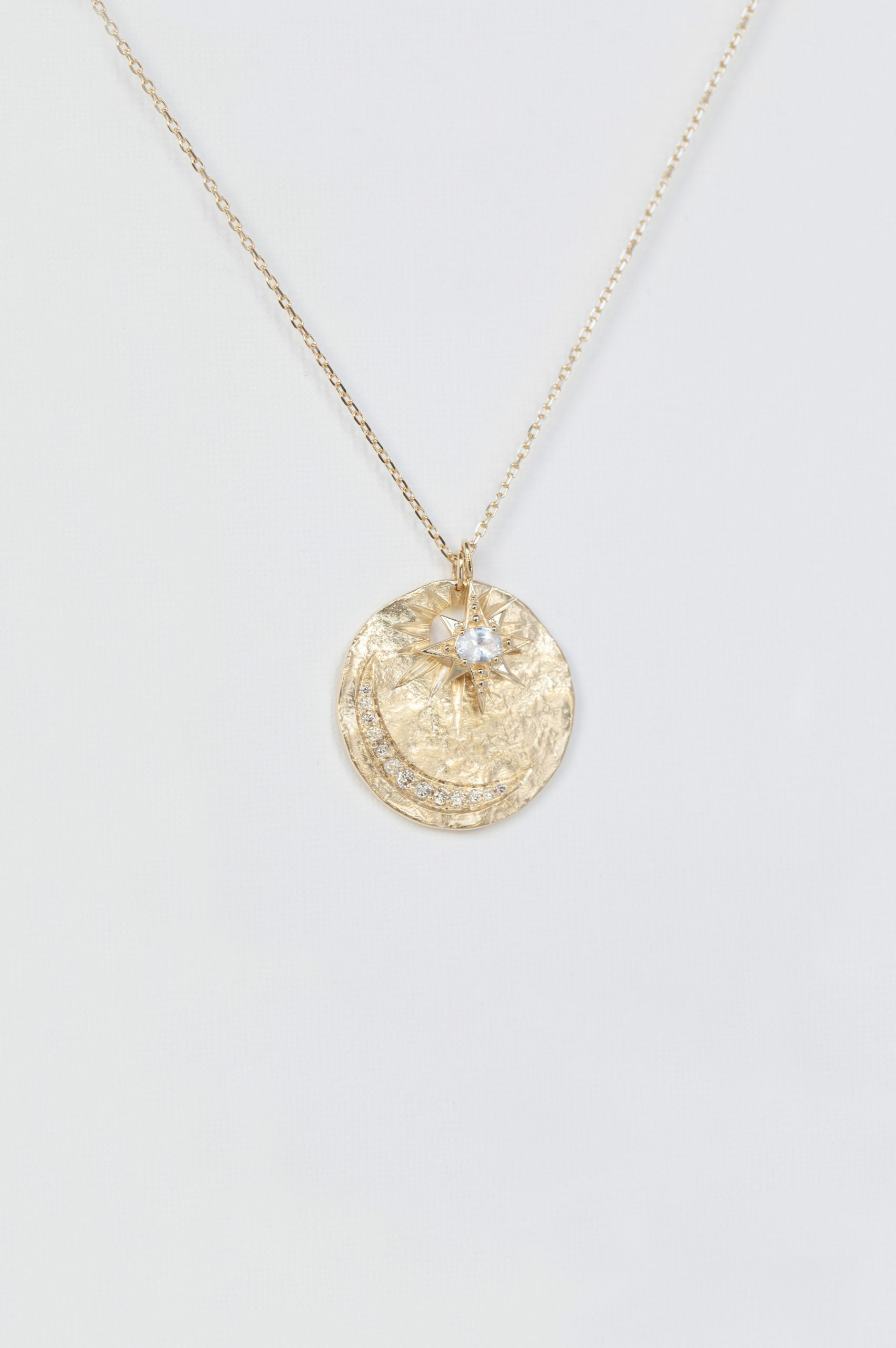 Yellow gold necklace round textured medal pendant diamond sapphire star moon eye motif Celine Daoust