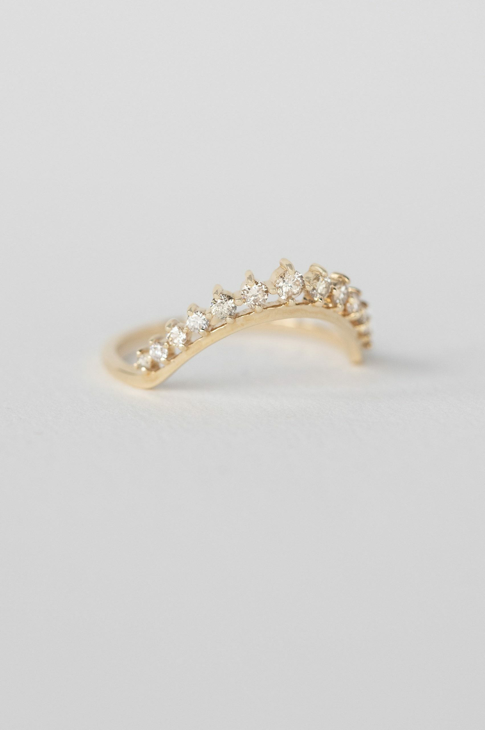 yellow gold curved crown ring with a wave-shaped band entirely pavé-set with round brilliant diamonds, creating a rich and luminous arc