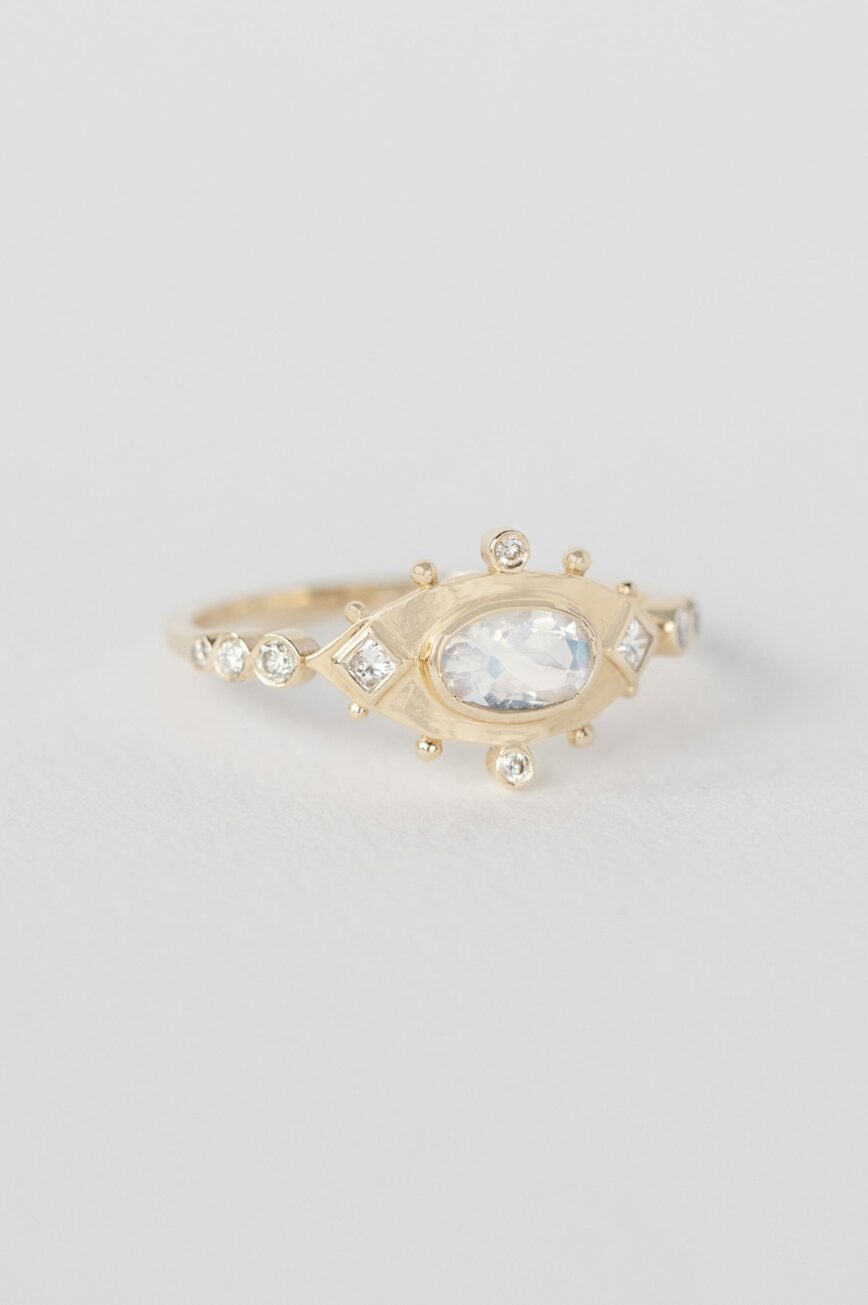 Yellow gold ring oval moonstone diamond accents eye motif band Celine Daoust