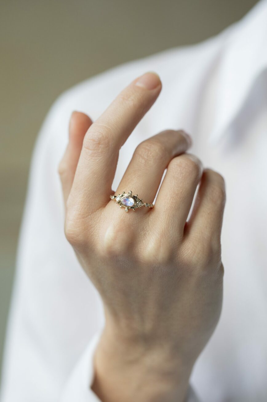 Yellow gold ring oval moonstone diamond accents eye motif band Celine Daoust