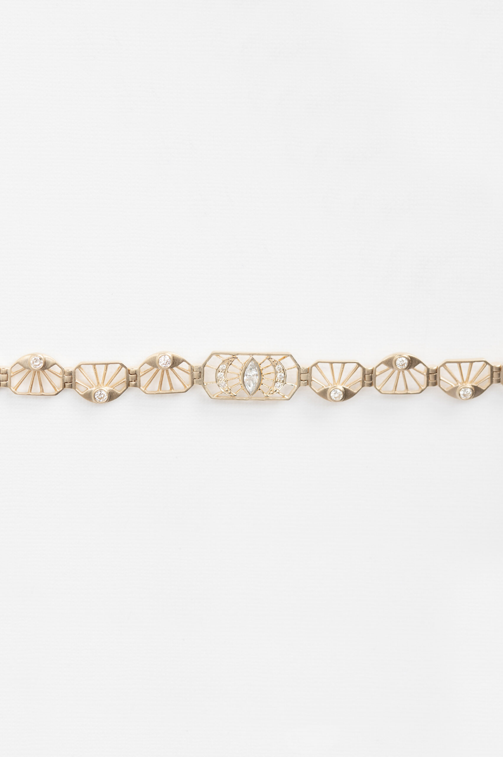 Yellow gold articulated bracelet diamond eye motif links worn on wrist Celine Daoust