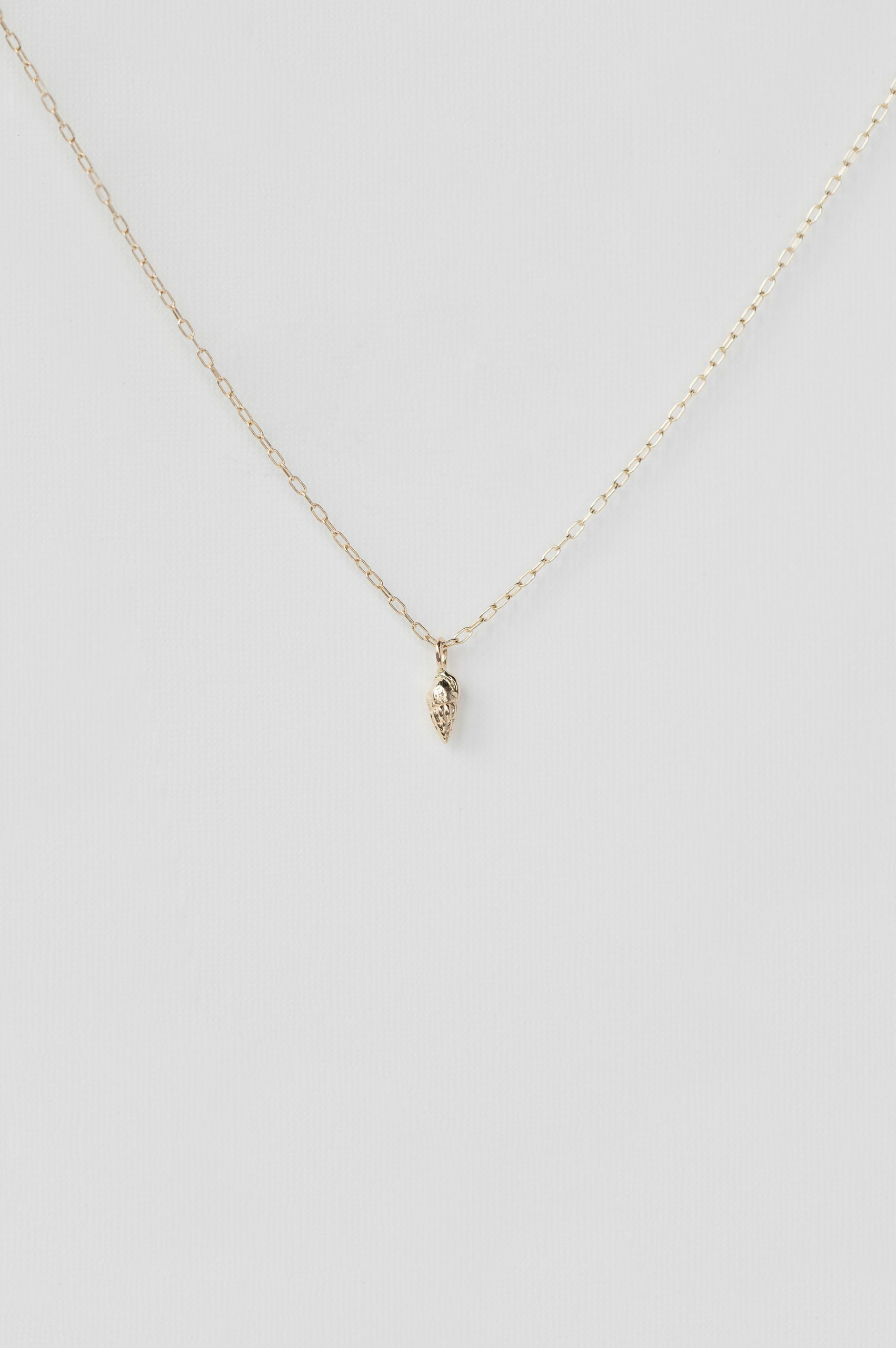 Yellow gold necklace small sculpted shell charm pendant delicate chain Celine Daoust