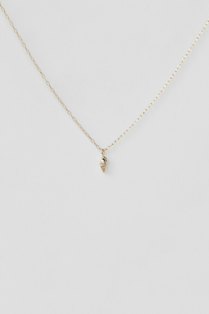 Yellow gold necklace small sculpted shell charm pendant delicate chain Celine Daoust