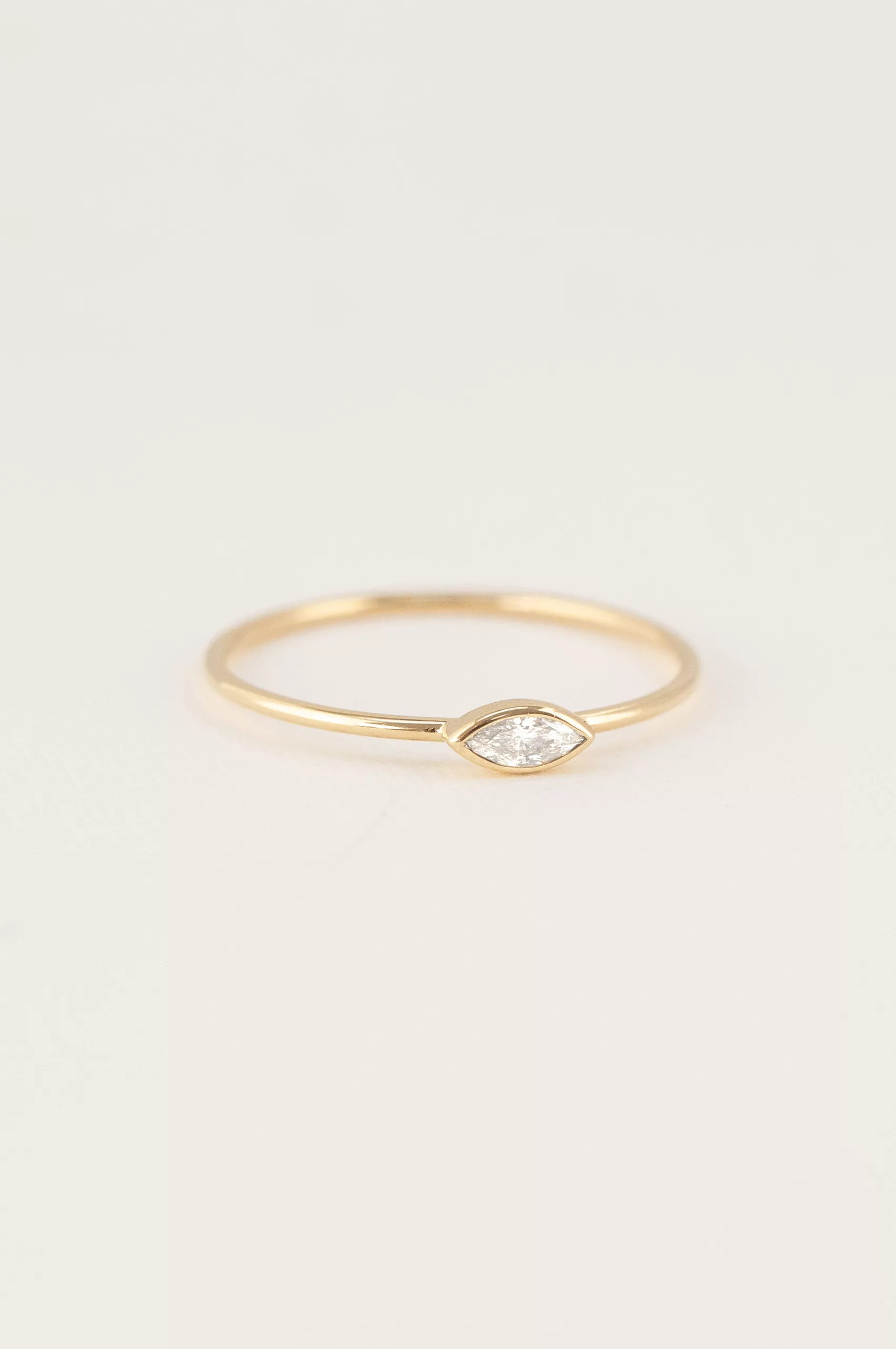 Yellow gold ring single marquise diamond open bezel slim band Celine Daoust