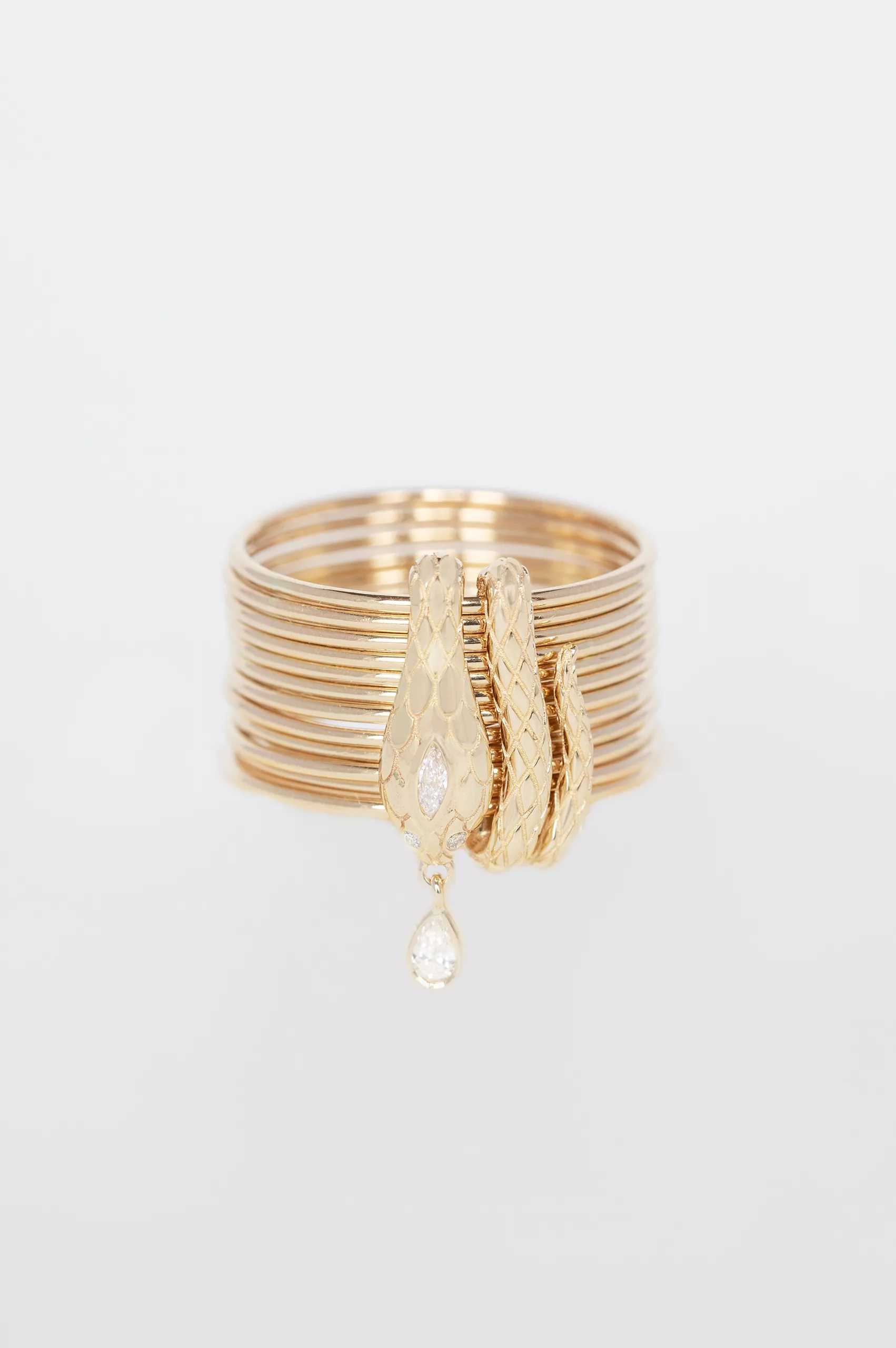 Yellow gold stacked multi-band ring sculpted cobra motif diamond drop charm Celine Daoust