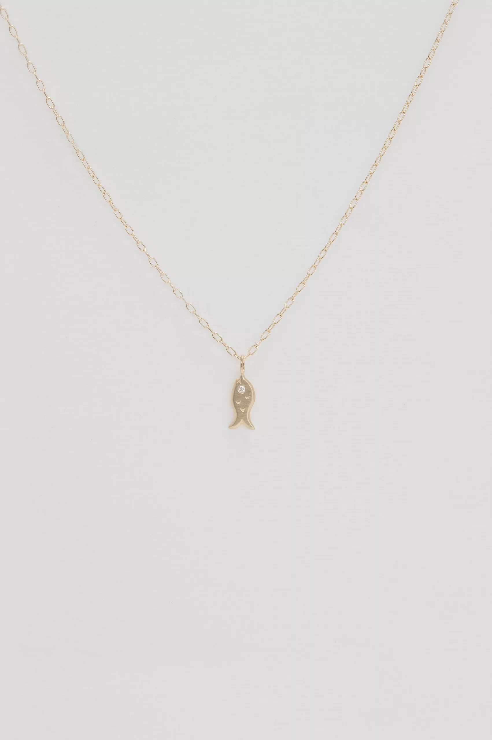 Gold necklace small fish charm pendant delicate chain Celine Daoust