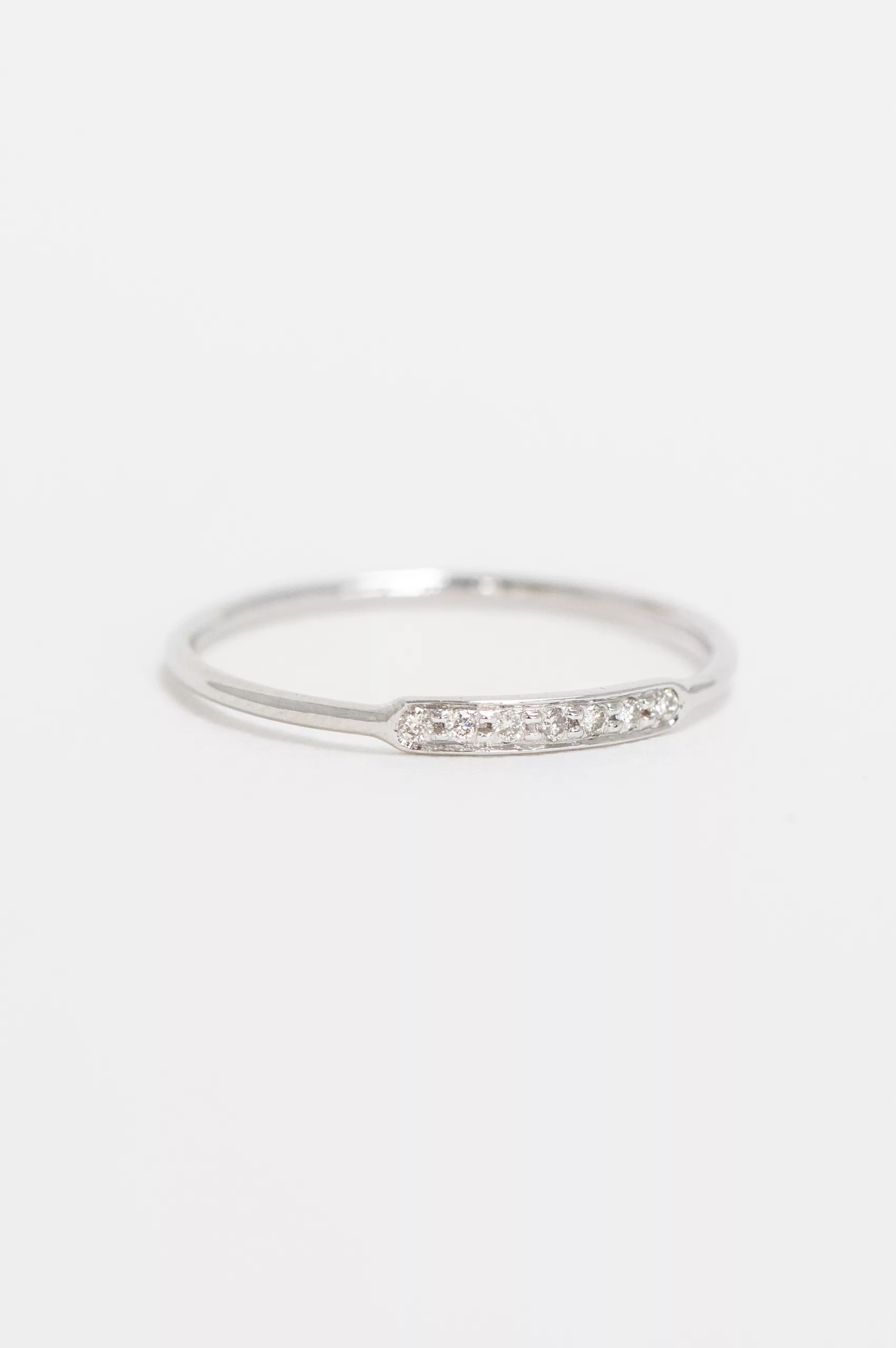 white gold slim band ring featuring a central rectangular pavé bar set with a row of tiny round brilliant diamonds