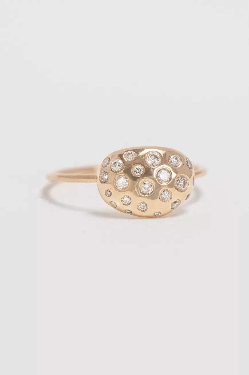 yellow gold ring with an oval dome-shaped shell motif pavé-set with round brilliant diamonds of varying sizes, mounted on a thin band