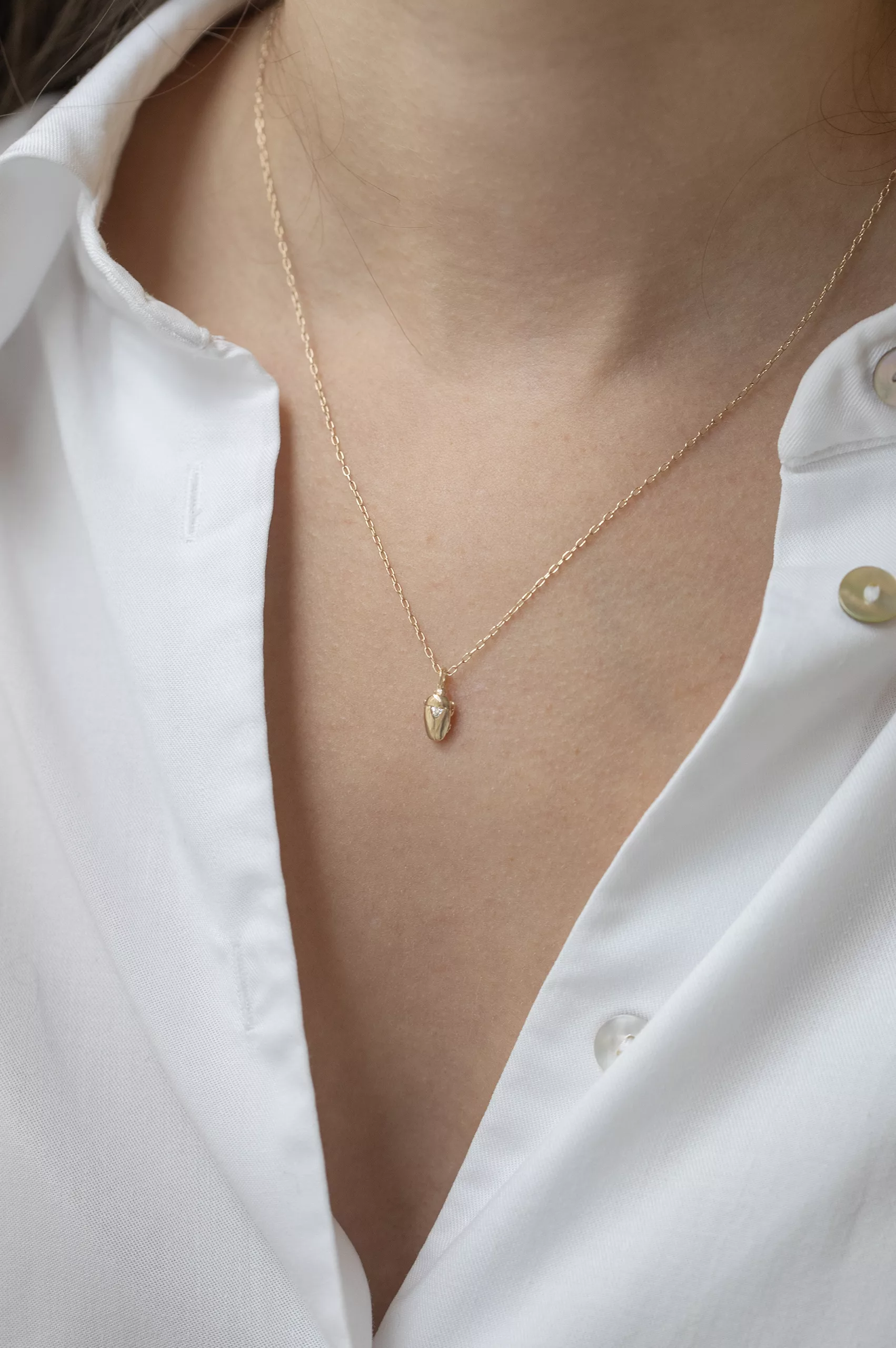 Yellow gold necklace small sculpted scarab pendant trillion diamond accent chain Celine Daoust