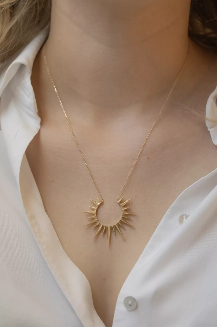 Yellow gold necklace large sun ray pendant worn on neck Celine Daoust