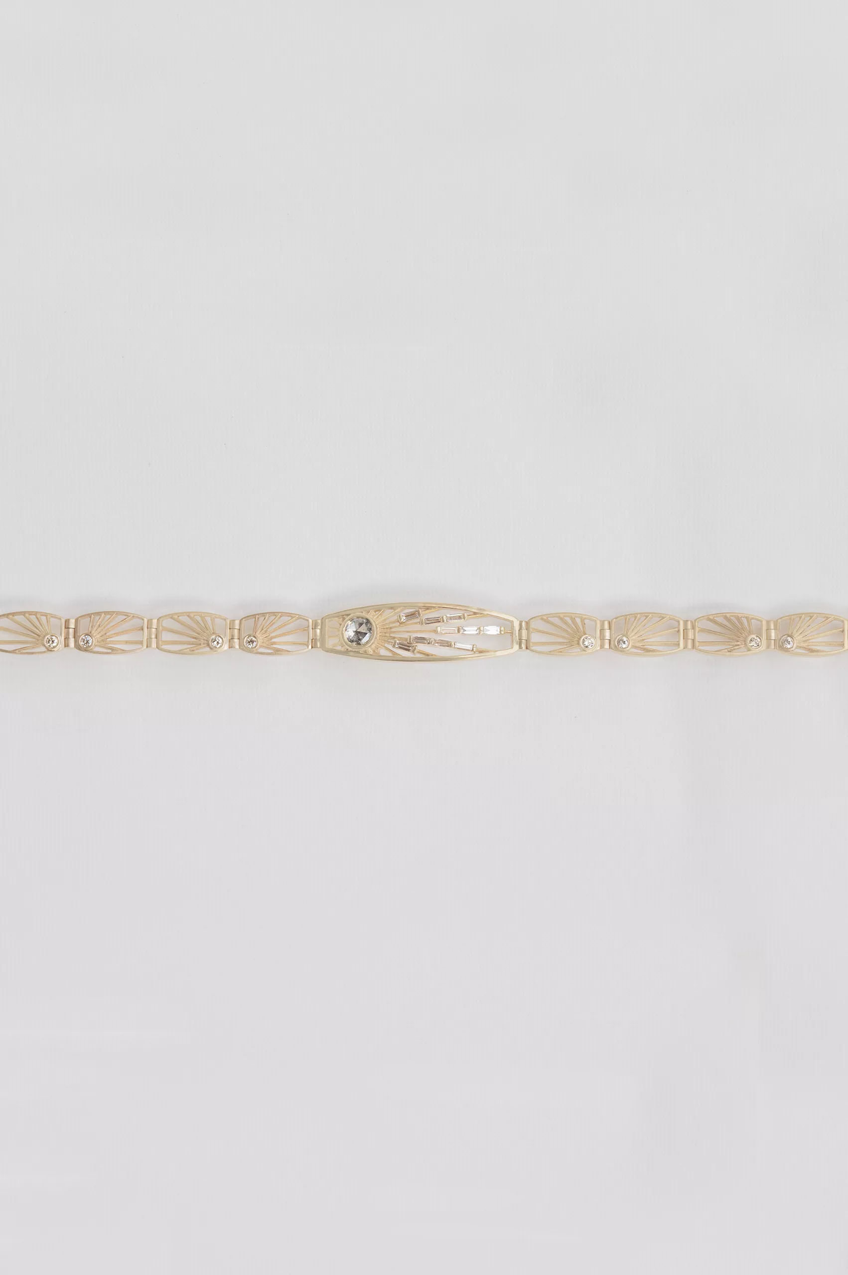 Gold articulated bracelet engraved sun links grey diamond center Céline Daoust