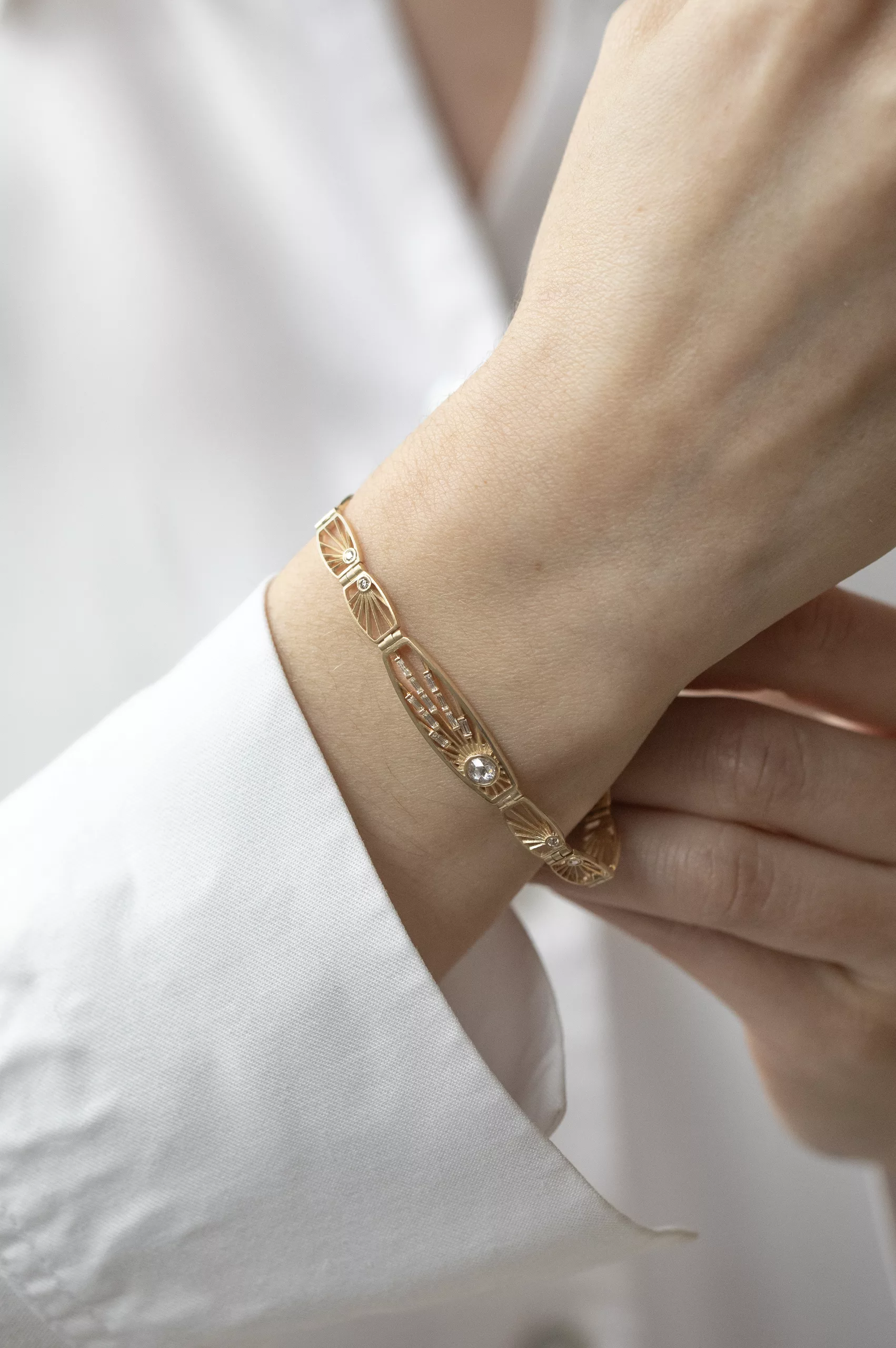 Gold articulated bracelet engraved sun links grey diamond center Céline Daoust
