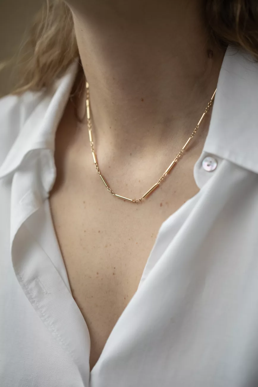 Yellow gold tube chain necklace worn on neck Celine Daoust