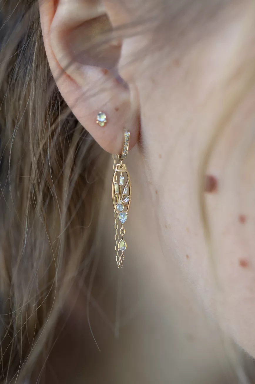 Gold drop earrings sculpted sun motif diamond accents chain fringe Céline Daoust