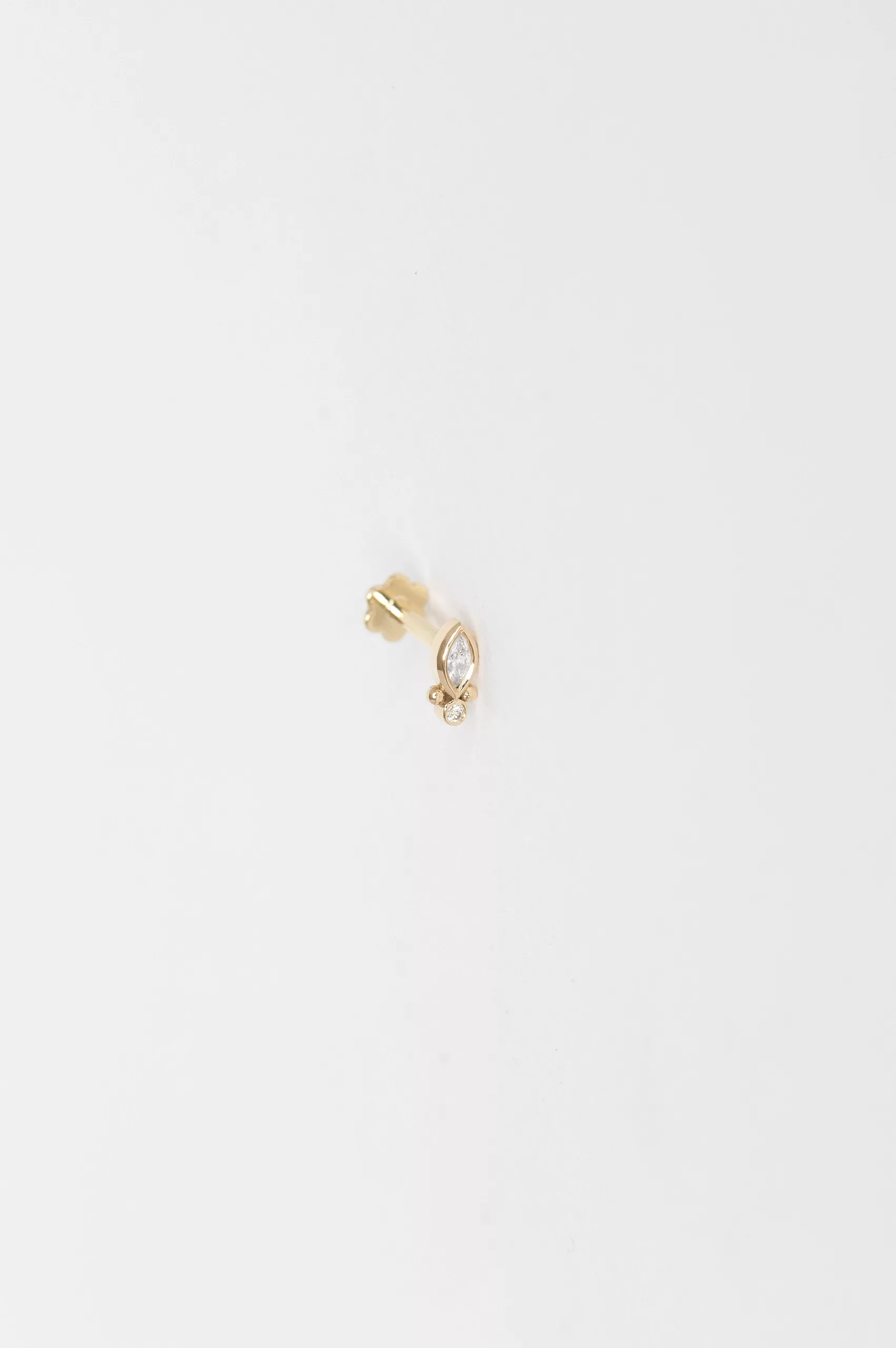 Yellow gold flat back piercing marquise diamond stud worn on ear Celine Daoust